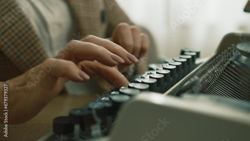 Nice well-groomed hands of lady in checkered jacket and white T-shirt working on vintage mechanical typewriter, sitting at table at daytime. Manual typing. High quality 4k footage