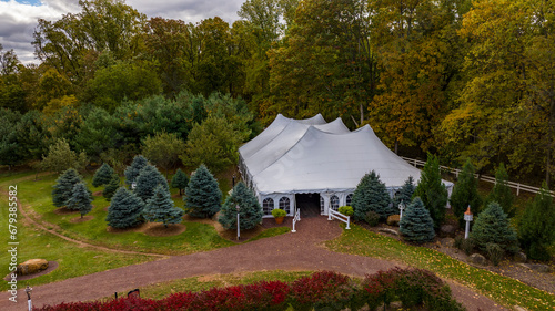 An Aerial View of a Large Tent in the Middle of all Kinds of Trees in Autumn