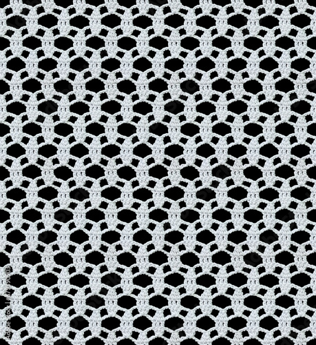 Snow white seamless knitted texture. Beautiful openwork lace crocheted. Cotton yarn. Guipure on a black background.