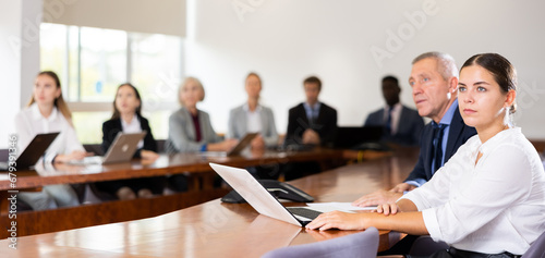 Εκτύπωση καμβά Side portrait of absorbed young white dark-haired businesswoman sitting with lat
