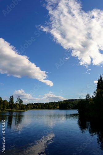 Fototapeta Naklejka Na Ścianę i Meble -  a body of water with clouds in the sky above it