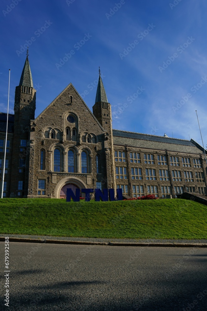 a large building with two steeple towers above the grass
