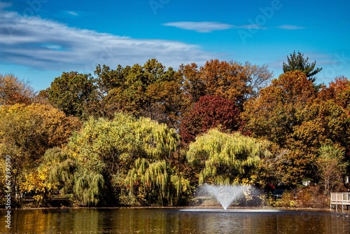 Scenic view of a fountain in a park on a sunny autumn day