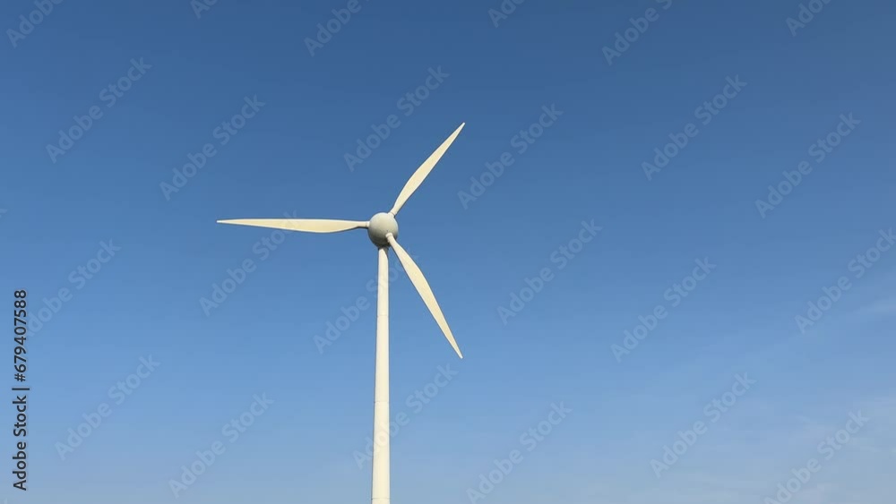Wind turbine working with clear blue sky in the background on a sunny day Wind turbine working with clear blue sky in the background on a sunny day