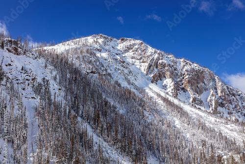 Snow-covered Top Notch Peak landscape in Yellowstone National Park Wyoming with blue sky.