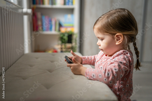 One girl toddler child play video game on mobile phone smartphone photo