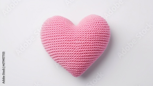 pink knitted heart on white background. Top view with copy space.