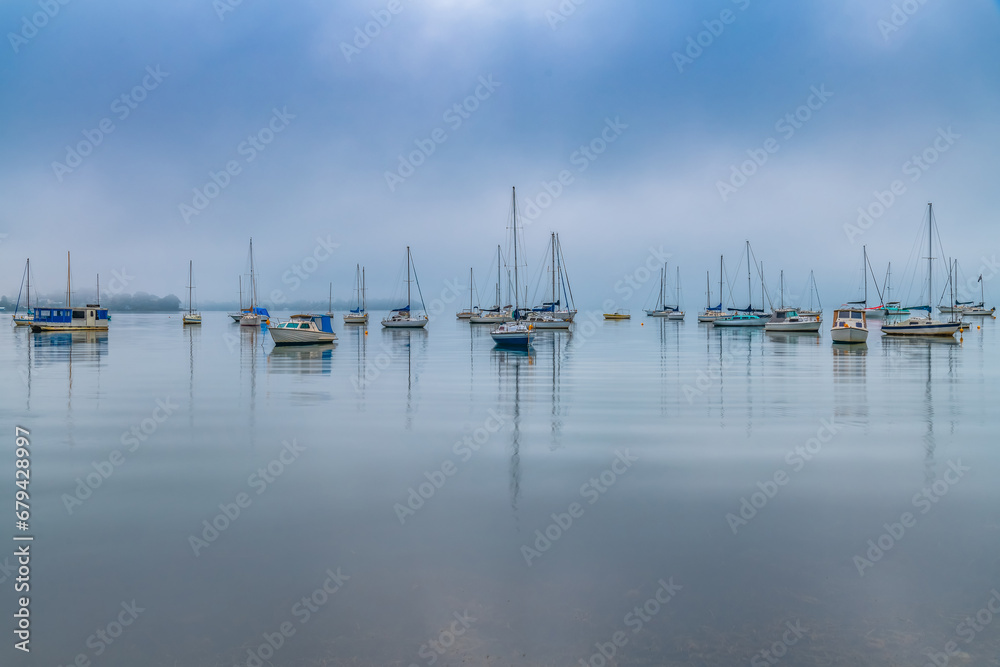 Fog, sunrise and boats on the bay