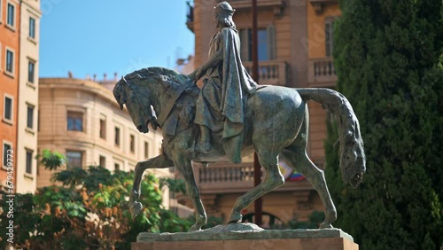 Close view of the Monument to Ramon Berenguer the Great in Barcelona, Spain. Greenery and old buildings on the background photo