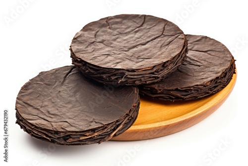 Flat puer tea discs isolated on white. Chinese Shou Puer. Fermented Pu-erh tea. Close-up. Aromatic healthy drink. photo