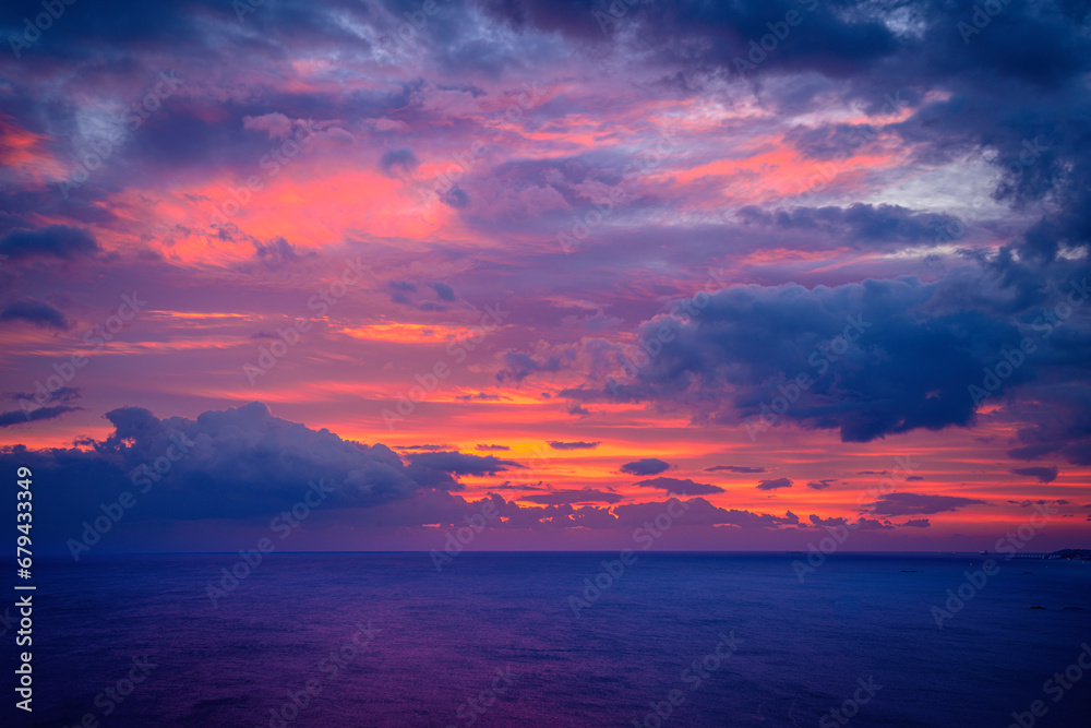 Sunrise Seascape at the East Sea in Korea, dramatic cloudscape and vibrant pink sun rays over the tranquil ocean at dawn in Sacheon Harbor of Gangneung City