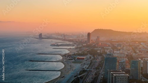 Aerial drone view of Barcelona at sunset, Spain. Mediterranean sea cost in city downtown with multiple buildings photo