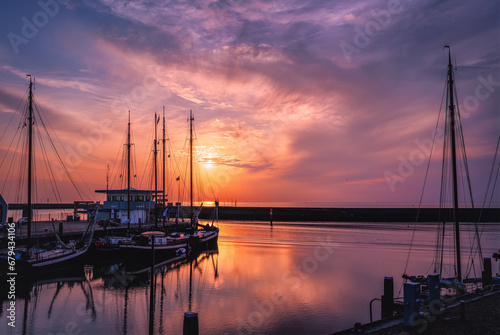Sailboats in the port of Harlingen (Netherlands) at sunset photo
