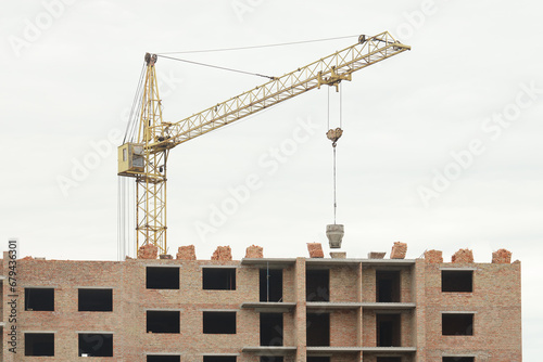 View of a large construction site with buildings under construction and multi-storey residential homes. Tower cranes in action on blue sky background. Housing renovation concept. Crane during © mehaniq41