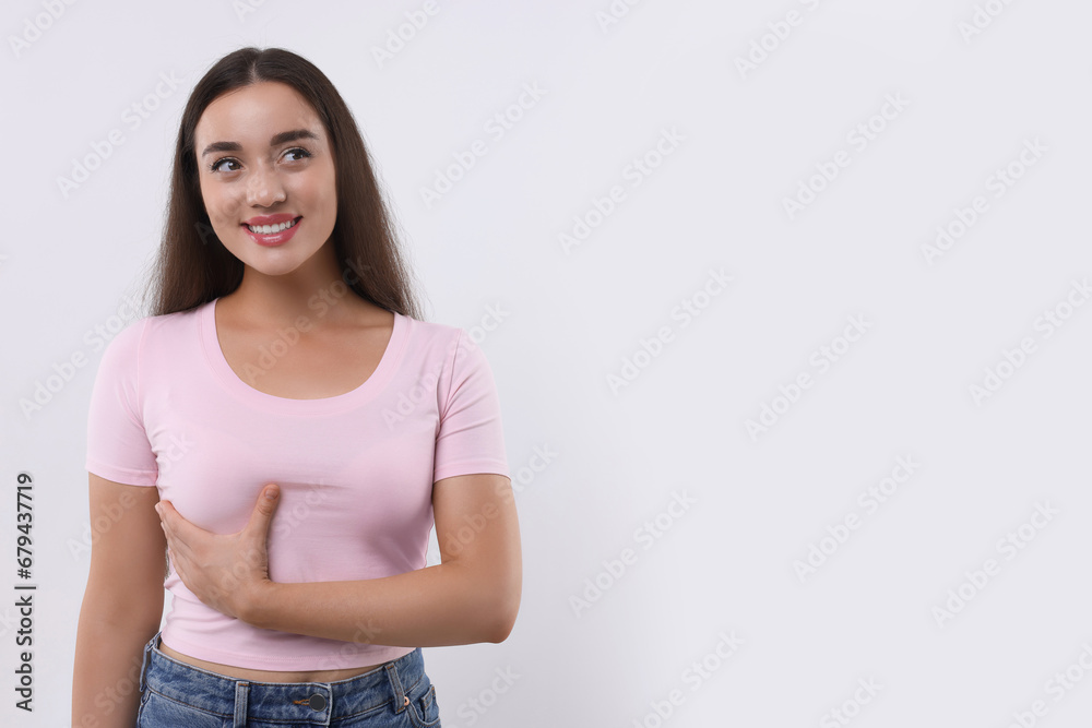 Beautiful happy woman doing breast self-examination on white background, space for text Beautiful happy woman doing breast self-examination on white background, space for text