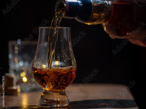 Glasses of single malt and blended scotch whisky served in bar in Edinburgh, Scotland, UK with party lights on background