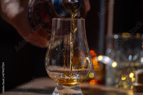 Glasses of single malt and blended scotch whisky served in bar in Edinburgh, Scotland, UK with party lights on background