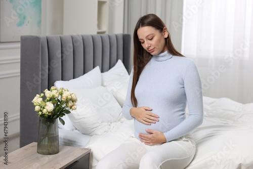 Beautiful pregnant woman with long hair in bedroom