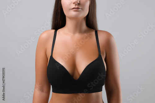 Woman with beautiful breast on light grey background, closeup