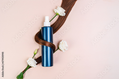 Spray for hair styling 
and flowers. Hair care product and beautiful Shiny healthy hair. Cosmetics. Mask for dry hair, shampoo, conditioner. Eco care product. bottle mockup. 	brunette