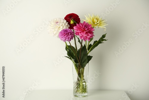 Bouquet of beautiful Dahlia flowers in vase on white table