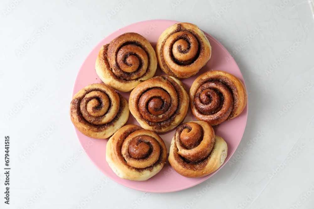Many tasty cinnamon rolls on white table, top view Many tasty cinnamon rolls on white table, top view