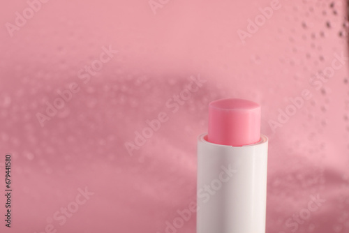 One lip balm on pink background, closeup. Space for text