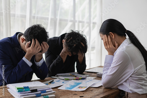 A group of stressed-out young Asian businessmen searching for a solution to a problem at a partnership meeting are left scratching their heads over bad news of a failed attempt. Feeling hopeless about photo
