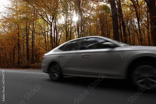 Modern car on asphalt road near autumn forest © New Africa