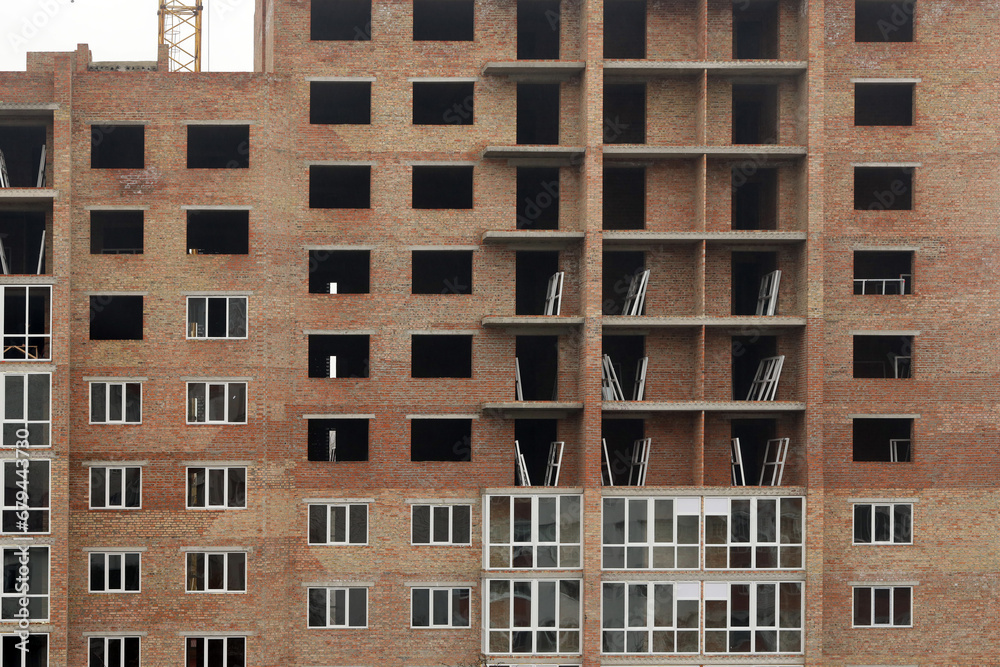 View of a large construction site with buildings under construction and multi-storey residential homes. Housing renovation concept View of a large construction site with buildings under construction and multi-storey residential homes. Housing renovation concept
