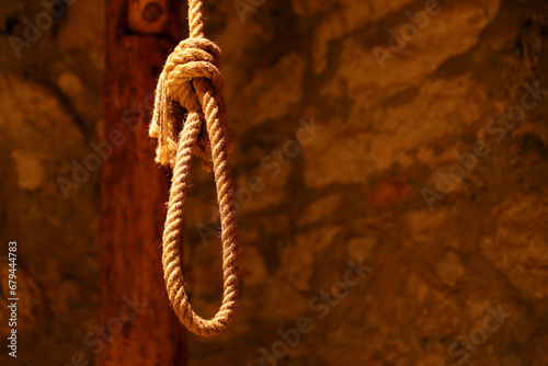 Noose in prison of old castle cellar and grunge stone wall close up photo