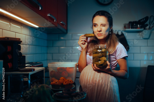 Pregnant Mother to be Craving some Pickles at Night. Funny girl smelling pickles in vinegar for morning sickness 
 photo
