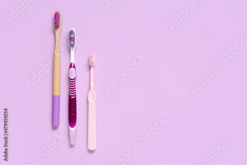Three different toothbrushes on color background.