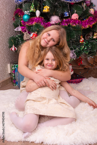  Beautiful elegant girls near the Christmas tree in the New Year. Holiday. New Year. Children are models. Two sisters. © Мария Иванова