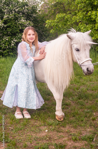  Portrait. A beautiful elegant girl with a magical fairy unicorn. A girl and a white pony. The child is a model.