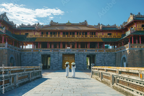 Ngo Mon gate - the main entrance of former Hue Imperial City in Hue city, Vietnam, with Vietnamese girls wearing traditional dress Ao Dai. Famous travel destination