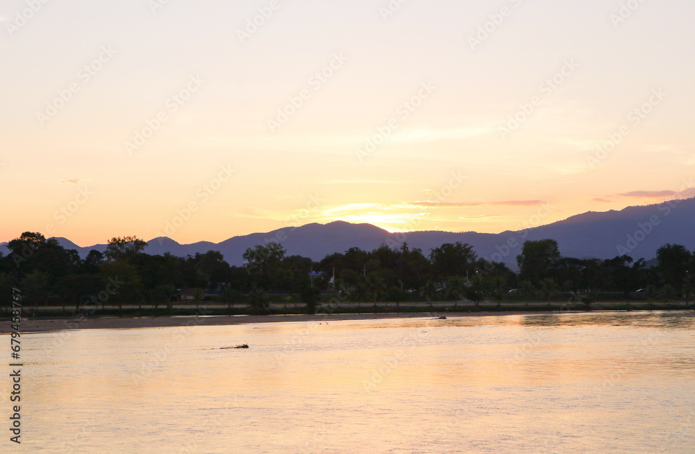 Aerial panoramic landscape with evening sunset over the river with islands and beautiful mountain clouds on golden yellow sky. Tourist attractions of Thailand.