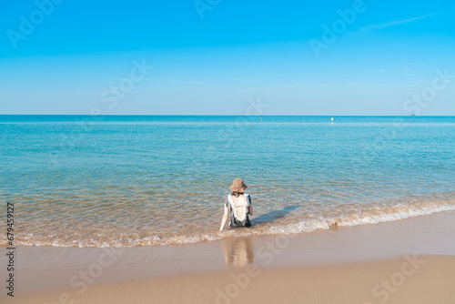 Tropical sea beach with young girl relaxing on sand