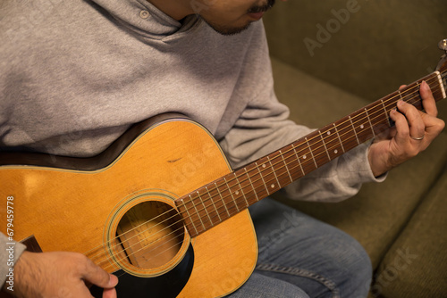 アコースティックギターを弾く男性の手元