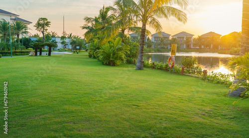 Vacation resort with grass field, green trees, early sunlight