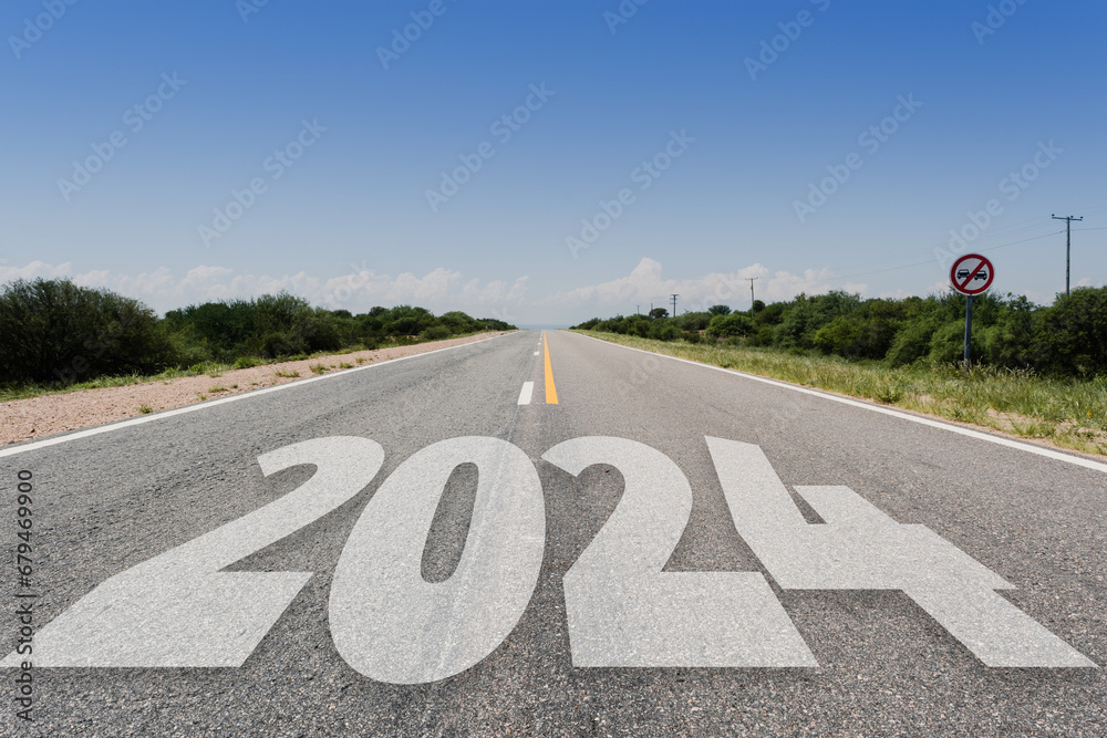Año nuevo 2024 o concepto de inicio.. Palabra 2024 escrita en la carretera asfaltada en día radiante. Concepto de desafío y cambio. - obrazy, fototapety, plakaty 