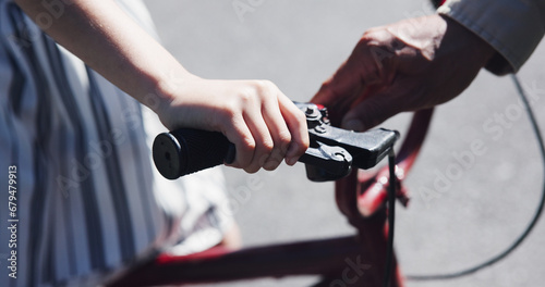 Closeup, child and teaching bicycle ride for safety, parent and neighbourhood with hands. Cycling, childhood memory and riding in summer, bonding together and handlebar with bike bell for alert