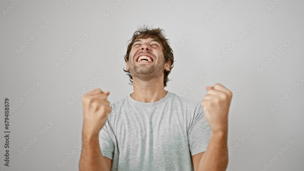 Yes! joyful bearded young man in t-shirt celebrating his win, arms triumphantly raised in success. isolated on white background, this casual and handsome blond guy's victory smile is everything! Yes! joyful bearded young man in t-shirt celebrating his win, arms triumphantly raised in success. isolated on white background, this casual and handsome blond guy's victory smile is everything!