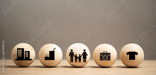 Human or family desire four requisites in life. Wood Icon food, clothing, house and medicine place on the table. four basic human needs concept. photo