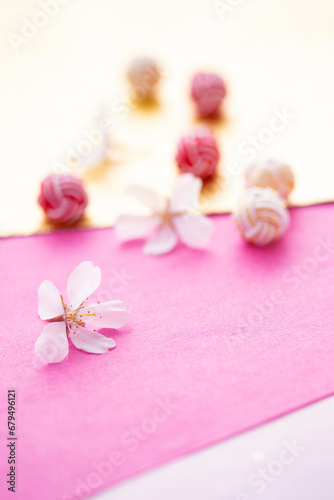 日本の正月イメージ 桜の花と水引玉と和紙のデザイン（ピンクと金色の和紙の背景）