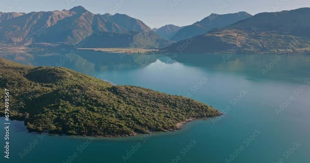 Pigeon island in calm lake Wakatipu surrounded by scenic mountains, aerial Pigeon island in calm lake Wakatipu surrounded by scenic mountains, aerial