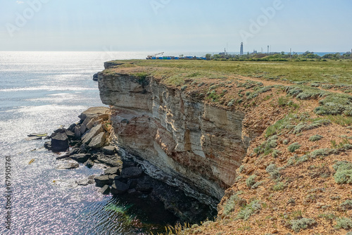 Cape Tarkhankut on the Crimean peninsula. The rocky coast of the Dzhangul Reserve in the Crimea. The Black Sea. Turquoise sea water. Rocks and grottoes of Cape Tarkhankut. photo
