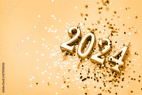 New Year 2024 celebration festive background with copy space made with golden candles in the form of number two thousand twenty four and sparkles. photo