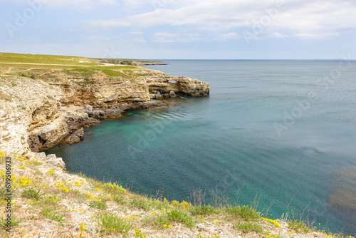Cape Tarkhankut on the Crimean peninsula. The rocky coast of the Dzhangul Reserve in the Crimea. The Black Sea. Turquoise sea water. Rocks and grottoes of Cape Tarkhankut. photo
