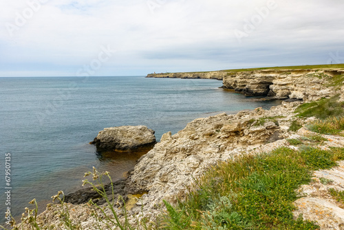 Cape Tarkhankut on the Crimean peninsula. The rocky coast of the Dzhangul Reserve in the Crimea. The Black Sea. Turquoise sea water. Rocks and grottoes of Cape Tarkhankut. photo